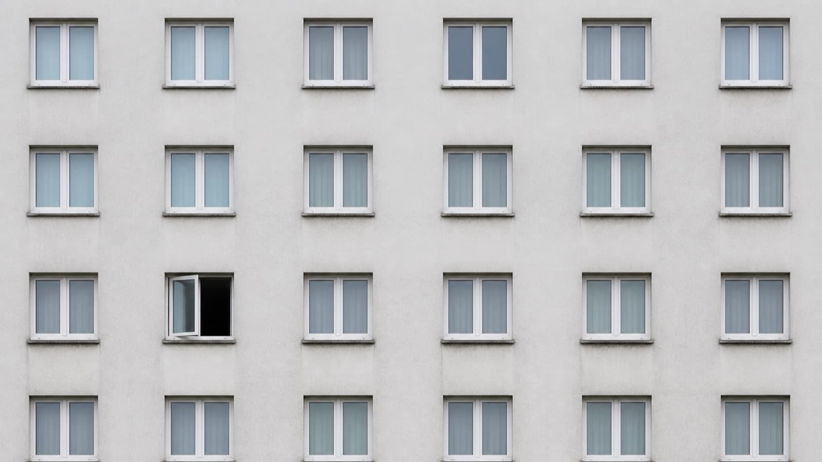 A rendered apartment facade of identical windows, one of them open.