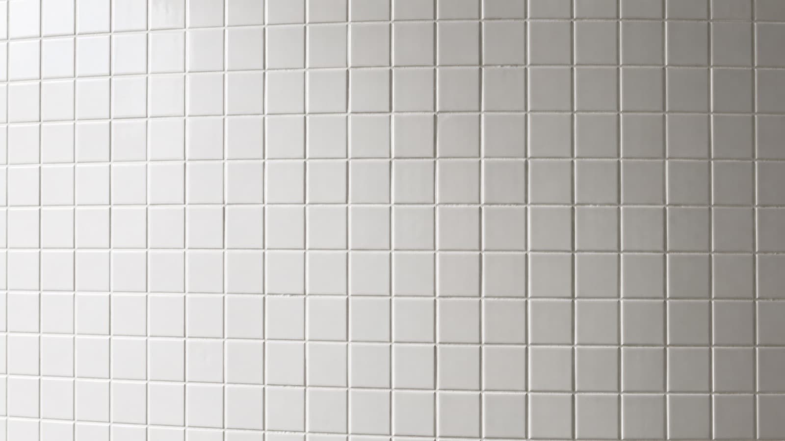 A wall of many identical small white tiles filling the frame.